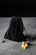 Charger l&#39;image dans la galerie, Sac de rangement en velours noir pour pièces d’échecs avec pions et cavalier en bois sur fond sombre
