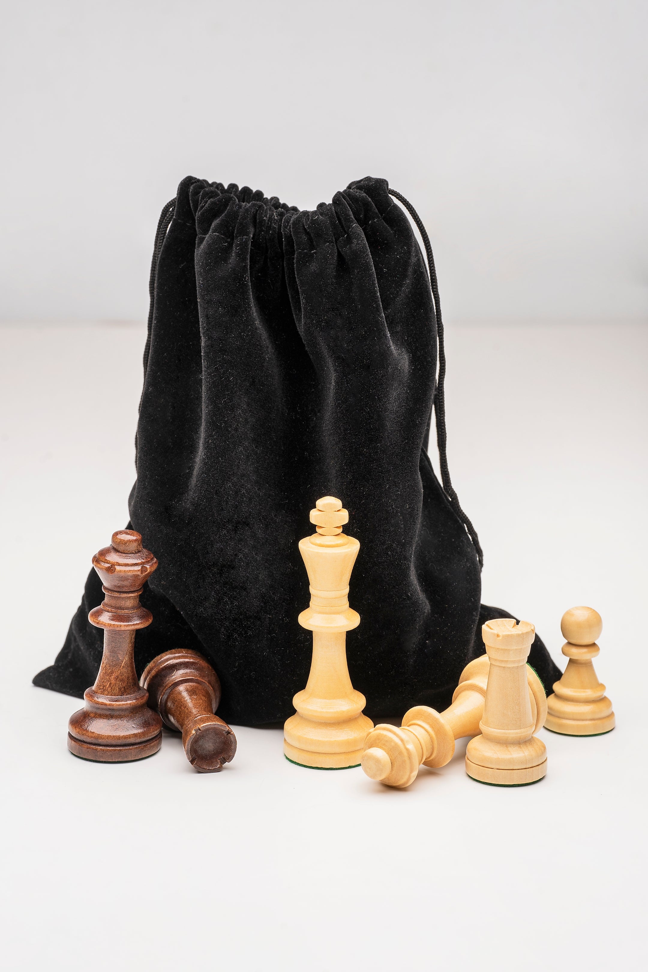 Sac de rangement en velours noir pour pièces d’échecs avec rois, tours et pions en bois clair et foncé